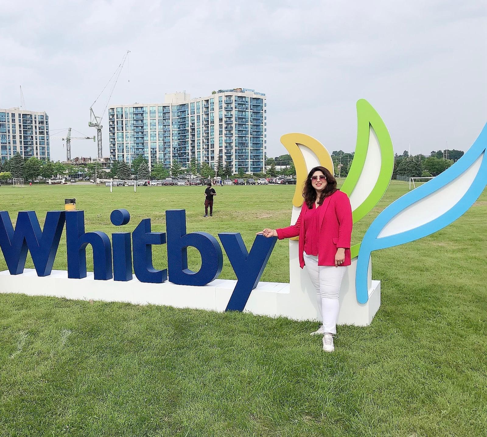 Saima Hammad beside the Whitby sign